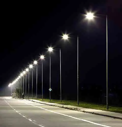 LED street lights illuminating a road at night.